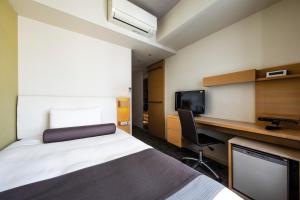 a hotel room with a bed and a desk and a tv at Tokyu Stay Kamata - Tokyo Haneda in Tokyo