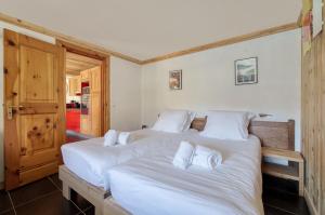 2 bedden in een kamer met witte lakens bij Appartement Petite Charline in Tignes