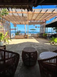 um pátio com uma mesa e cadeiras e o oceano em Ursula Beach Resort em El Nido
