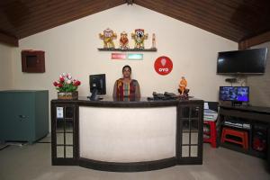 a woman standing behind a counter in a room at Hotel Sai Leela in Puri