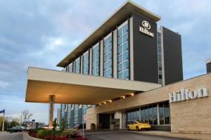 a hilton hotel with a yellow car parked outside at Hilton Toronto Airport Hotel & Suites in Mississauga