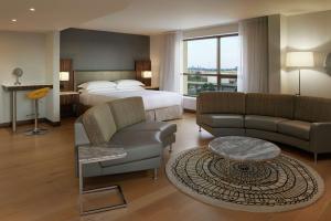 um quarto de hotel com uma cama, um sofá e uma mesa em Hilton Toronto Airport Hotel & Suites em Mississauga