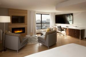 a bedroom with a living room with a fireplace at Hilton Toronto Airport Hotel & Suites in Mississauga