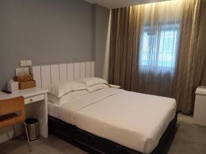 Postel nebo postele na pokoji v ubytování Kinabalu Daya Hotel