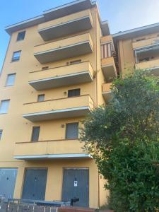 żółty budynek z drzewem przed nim w obiekcie vicinissima ospedale Cisanello Casa Francesca w Pizie