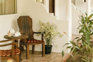 a table and chair next to a staircase with plants at Villa Elegance in Galle