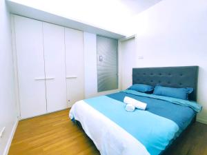 ein Schlafzimmer mit einem großen Bett mit blauer Bettwäsche und blauen Kissen in der Unterkunft 1 Mont Kiara - Sri Hartamas -International Schools - Kiara 1 in Kuala Lumpur