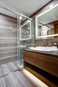 a bathroom with a tub and a sink and a mirror at Sheraton Grand Samsun Hotel in Samsun