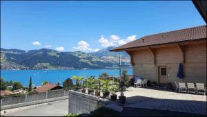 a house with a view of a body of water at Swiss Apartment Thunersee in Einigen