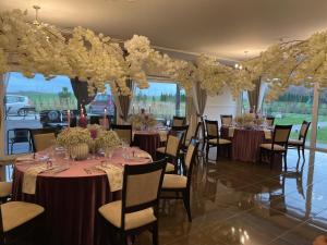 a banquet hall with tables and chairs with flowers at Villa Orchidea in Šakiai