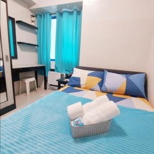1 dormitorio con 1 cama con toallas en Sea Residences by Jan & Val Alano en Manila