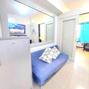 a blue couch in a kitchen with a refrigerator at Sea Residences by Jan & Val Alano in Manila