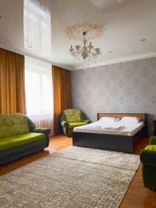 een slaapkamer met een bed, een bank en een kroonluchter bij 458 Рядом Байтерек с кондиционером 2 большими кроватями и раскладным диваном для компании 1-6 человек in Astana
