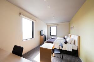 a bedroom with a bed and a desk and two windows at Tokyu Stay Kamata - Tokyo Haneda in Tokyo