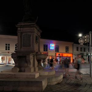 a statue in the middle of a street at night at Schlossquadrat Apartement 14 A in Vienna