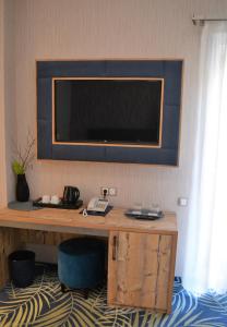 a room with a desk with a television on the wall at ART Hotel in Sibiu