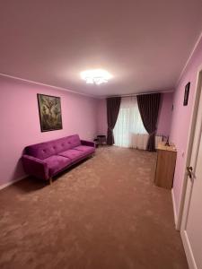 un soggiorno con divano viola in una camera di Apartament Ingrid a Piatra Neamţ