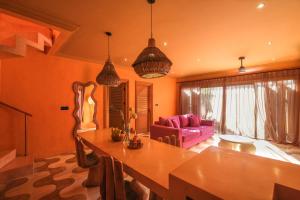 ein Wohnzimmer mit einem Tisch und einem lila Sofa in der Unterkunft El Barrio Boutique Hotel & Bar in Canggu