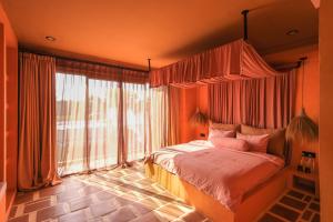 a bedroom with a bed and a large window at El Barrio Boutique Hotel & Bar in Canggu