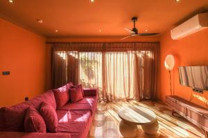 sala de estar con sofá rojo y mesa en El Barrio Boutique Hotel & Bar, en Canggu