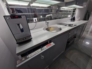 una cucina con lavandino e bancone con specchio di Maxim Apartment Pobierowo a Pobierowo Altre 29 foto