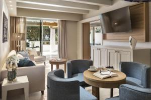 a living room with a couch and a table and chairs at Hotel La Bisaccia in Baja Sardinia