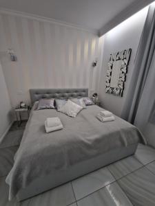Maxim Apartment Pobierowo في بوبيروفو: غرفة نوم بسرير كبير عليها منشفتين