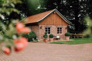 a small brick house with potted plants in front of it at Ferienhof Werner in Emstek