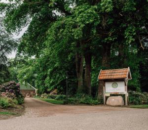 a sign in the middle of a dirt road with trees at Ferienhof Werner in Emstek