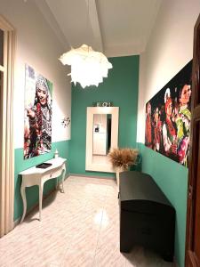 a room with green walls with a desk and posters at Zigana- Raffinato ed elegante appartamento nel cuore della città! in Palermo