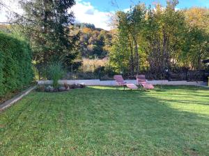 two benches sitting in the grass in a yard at Apartman BAGI in Kiseljak