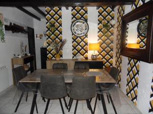 a dining room with a table and a clock on the wall at Le clos des tuileries in Montholon