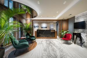 a lobby with a fireplace and green chairs at Nex Hotel & Spa Istanbul in Istanbul