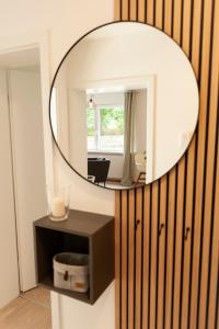 a round mirror on a wall in a room at FreiTraum Apartments No1 im Zentrum von Bad Neustadt in Bad Neustadt an der Saale