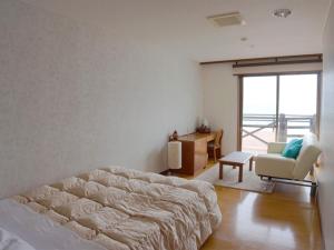 Schlafzimmer mit einem Bett, einem Schreibtisch und einem Stuhl in der Unterkunft Marine Blue Yakushima in Yakushima