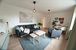 ein Wohnzimmer mit einem blauen Sofa und einem Tisch in der Unterkunft FreiTraum Apartments No1 im Zentrum von Bad Neustadt in Bad Neustadt an der Saale
