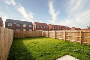 a backyard with a wooden fence and houses at Modern, Stylish House with Free Parking and Garden in Humberston