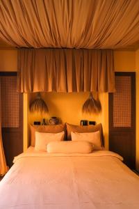 sypialnia z dużym łóżkiem z białą pościelą w obiekcie El Barrio Boutique Hotel & Bar w mieście Canggu