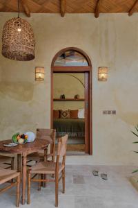 a dining room with a table and chairs and a mirror at Lina Boutique Villas and Spa in Kuta Lombok