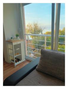 Cette chambre dispose d'un canapé et d'une grande fenêtre. dans l'établissement APARTMENT ANA v-Peshtani, à Ohrid
