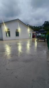 un gran edificio blanco con luces en un aparcamiento en BAUNG GUEST HOUSE TEMERLOH en Temerloh