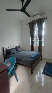 BAUNG GUEST HOUSE TEMERLOH في تيميرلوه: غرفة نوم بسرير وطاولة ونافذة زرقاء