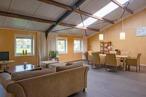 a living room with a couch and a table and chairs at opdehoekvandestal in Workum