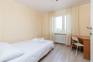 ein Schlafzimmer mit Bett, Schreibtisch und Fenster in der Unterkunft Osiedle Kombatantów Standard Apartment in Krakau