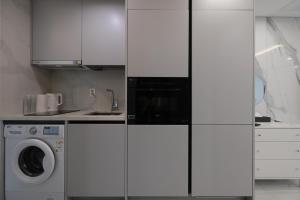 a kitchen with white cabinets and a washing machine at Zizel Raonjae 2 in Seoul