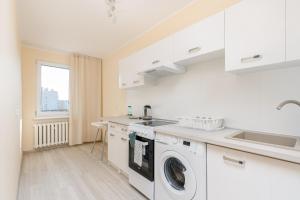 eine Küche mit Waschmaschine und Spüle in der Unterkunft Osiedle Kombatantów Standard Apartment in Krakau