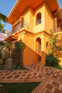 ein gelbes Haus mit einem Balkon und einer Terrasse in der Unterkunft El Barrio Boutique Hotel & Bar in Canggu