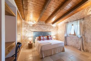 a bedroom with a bed and a stone wall at Trullo Fantastico in Castellana Grotte