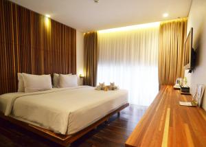 a bedroom with a large bed and a large window at Greenhost Boutique Hotel Prawirotaman in Yogyakarta