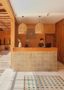 a man sitting at a bar with a laptop at Lina Boutique Villas and Spa in Kuta Lombok